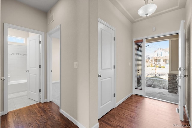 foyer with visible vents, baseboards, and wood finished floors