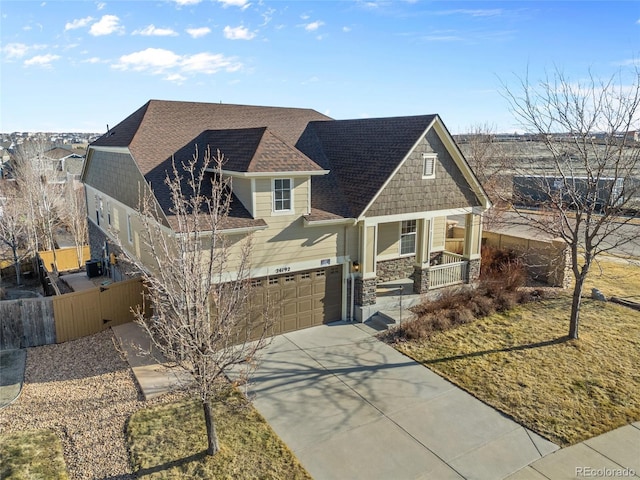 craftsman house with a porch, a shingled roof, concrete driveway, fence, and a garage