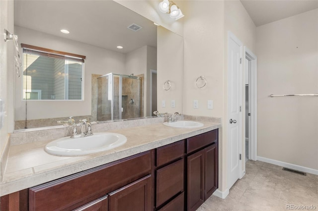 bathroom with visible vents, a sink, a shower stall, and double vanity