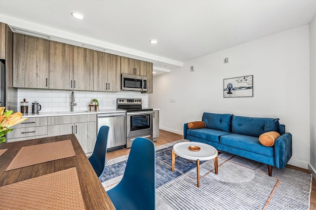 living room with light hardwood / wood-style floors and sink