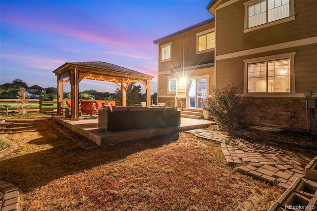 yard at dusk with a gazebo, outdoor lounge area, and a patio