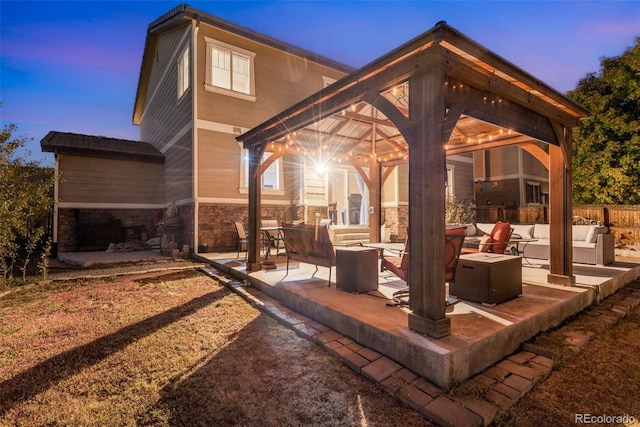 patio terrace at dusk featuring a gazebo and an outdoor living space