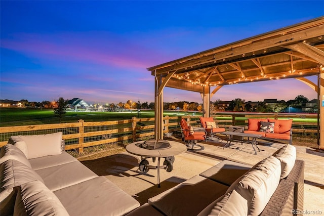 patio terrace at dusk with a gazebo and an outdoor living space with a fire pit