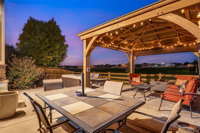 patio terrace at dusk with a gazebo and an outdoor hangout area