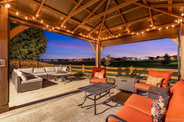 patio terrace at dusk featuring an outdoor living space and a gazebo