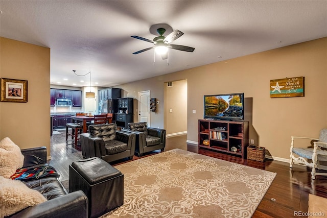 living room with dark hardwood / wood-style floors and ceiling fan