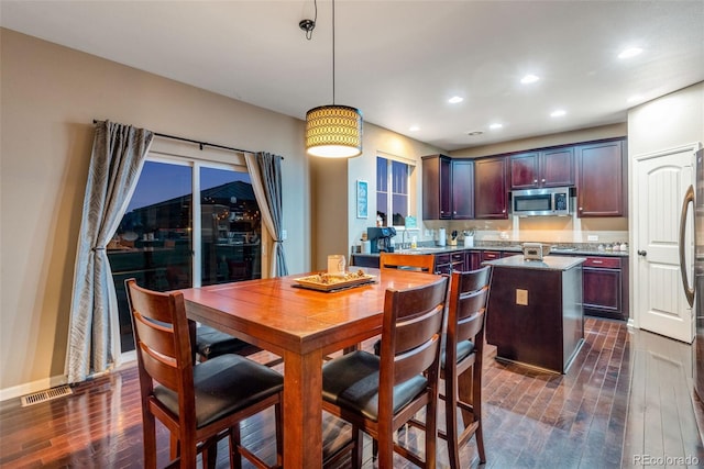 dining room featuring sink and dark wood-type flooring