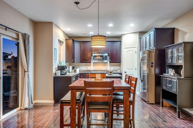 kitchen featuring stainless steel appliances, pendant lighting, dark hardwood / wood-style floors, and dark brown cabinetry