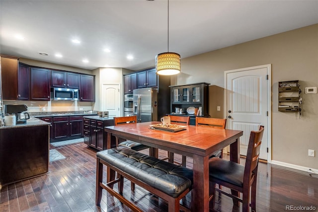 kitchen featuring stainless steel appliances, pendant lighting, dark hardwood / wood-style floors, and dark brown cabinets