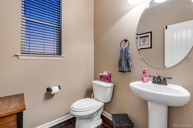 bathroom with hardwood / wood-style floors, sink, and toilet