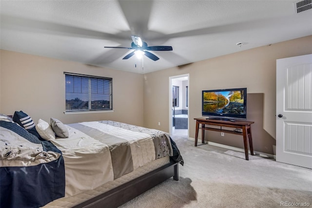 carpeted bedroom featuring ceiling fan, a textured ceiling, and ensuite bathroom