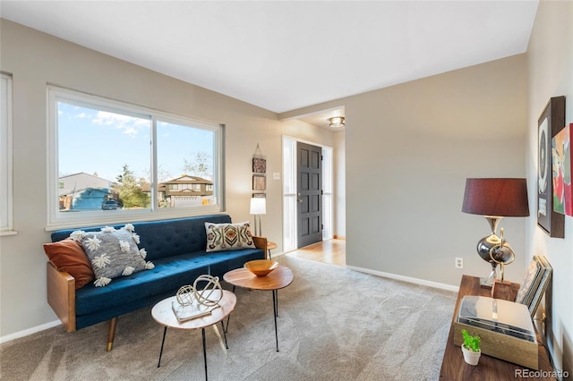 carpeted living area featuring baseboards