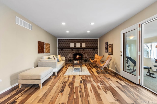 living room featuring light wood-type flooring, visible vents, baseboards, and recessed lighting