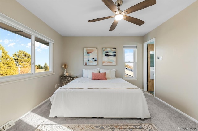 bedroom featuring baseboards, multiple windows, visible vents, and light colored carpet