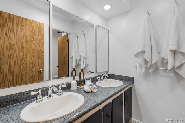 full bath featuring a sink, toilet, and double vanity