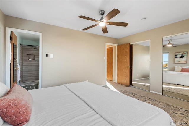 bedroom with carpet floors, connected bathroom, baseboards, and two closets