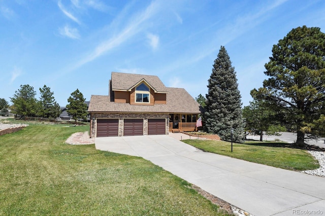 traditional-style house with concrete driveway, stone siding, and a front lawn