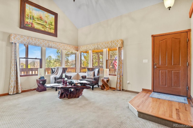 living room featuring a wealth of natural light, carpet floors, high vaulted ceiling, and baseboards