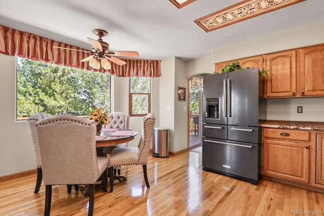 kitchen featuring light wood-type flooring, ceiling fan, brown cabinetry, and high end refrigerator