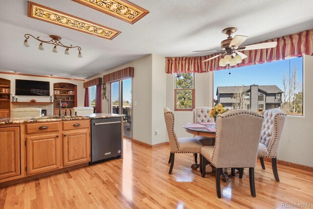 dining room featuring light wood-style flooring, baseboards, and a ceiling fan