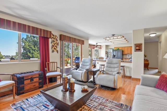 living area featuring light wood-style floors and baseboards