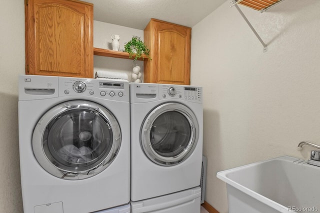 laundry area featuring independent washer and dryer, cabinet space, and a sink