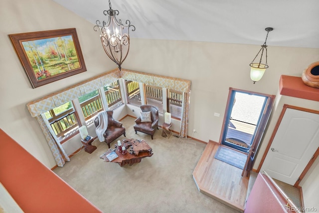 living room featuring a healthy amount of sunlight, an inviting chandelier, carpet floors, and vaulted ceiling