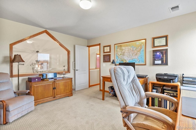 office area featuring baseboards, light carpet, and visible vents