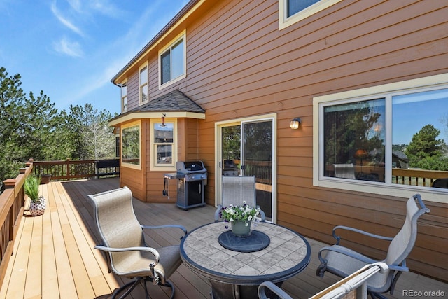 deck featuring a grill and outdoor dining area