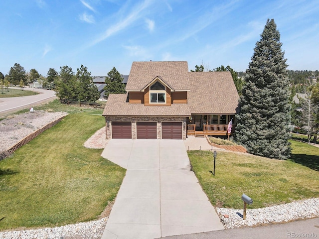view of front facade with covered porch, stone siding, a front lawn, roof with shingles, and driveway