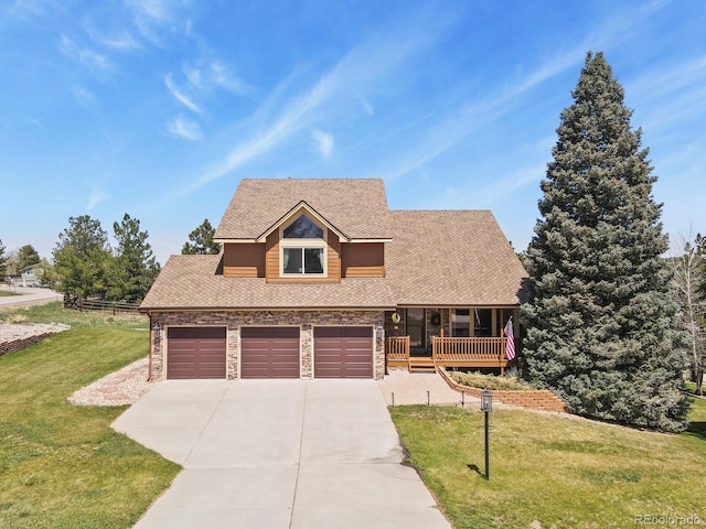 view of front of property with roof with shingles, driveway, stone siding, and a front yard