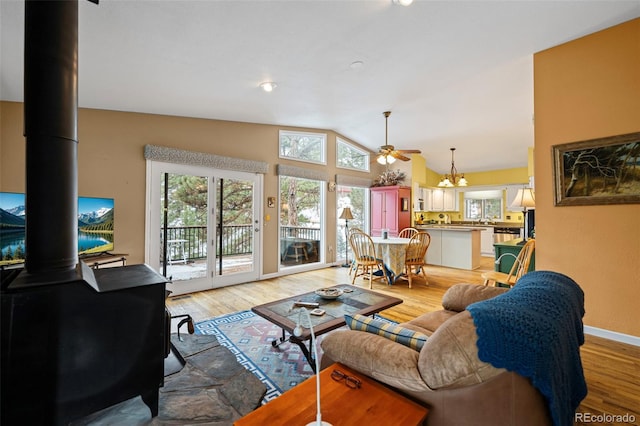 living room featuring lofted ceiling, light wood-type flooring, and a wood stove