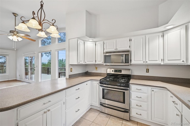 723 Eaton Rd, Palmer Lake, CO 80133 - kitchen with light tile patterned floors, ceiling fan, stainless steel appliances, white cabinets, and a peninsula