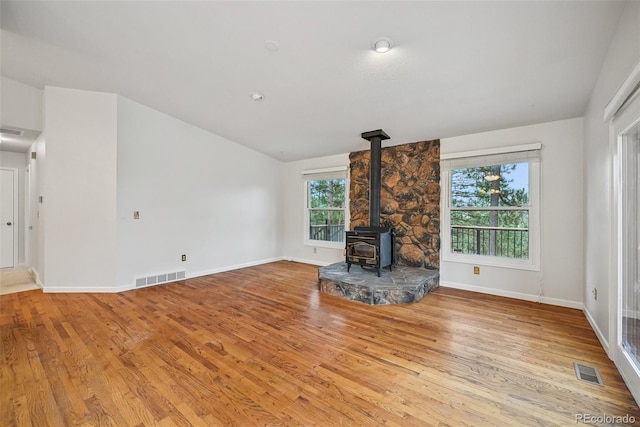 723 Eaton Rd, Palmer Lake, CO 80133 - unfurnished living room with baseboards, a wood stove, wood finished floors, and visible vents