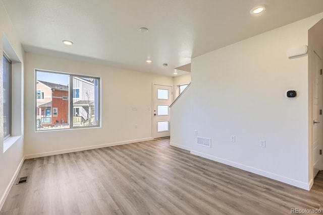 unfurnished room with hardwood / wood-style floors and a wealth of natural light