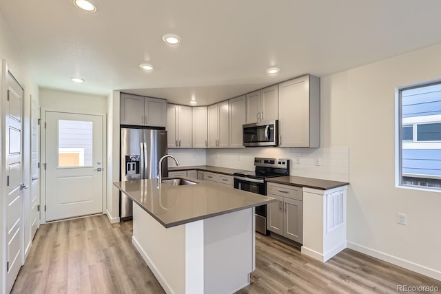 kitchen featuring sink, decorative backsplash, gray cabinets, and stainless steel appliances