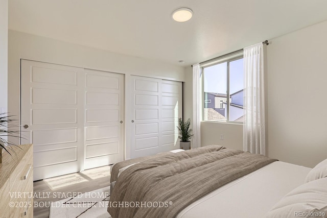 bedroom featuring multiple closets and wood-type flooring