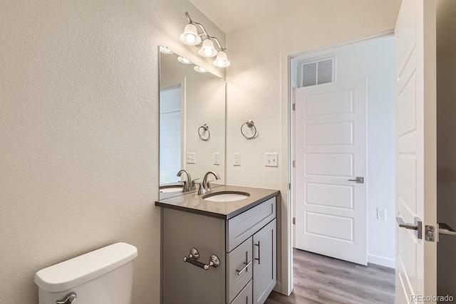 bathroom featuring wood-type flooring, vanity, and toilet