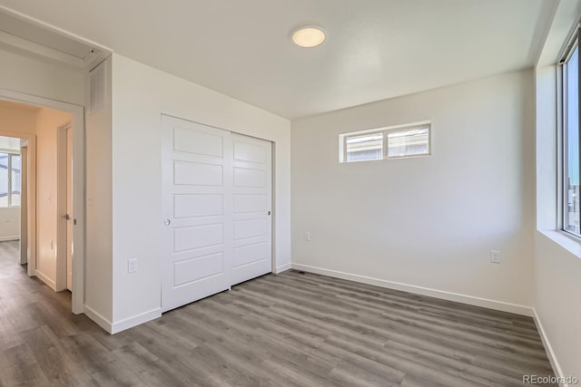 unfurnished bedroom with wood-type flooring and a closet