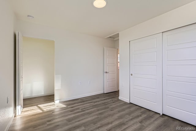 unfurnished bedroom with dark hardwood / wood-style flooring and a closet