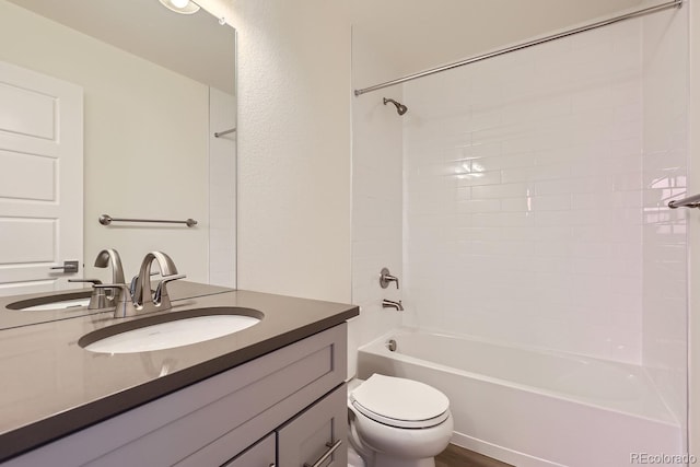 full bathroom featuring vanity, tiled shower / bath combo, and toilet