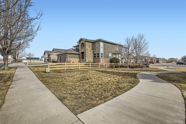 exterior space with a residential view, stone siding, and fence