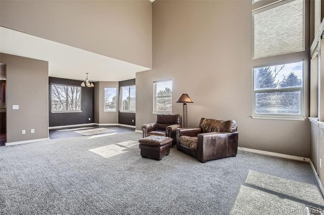 living area featuring carpet, baseboards, and a high ceiling