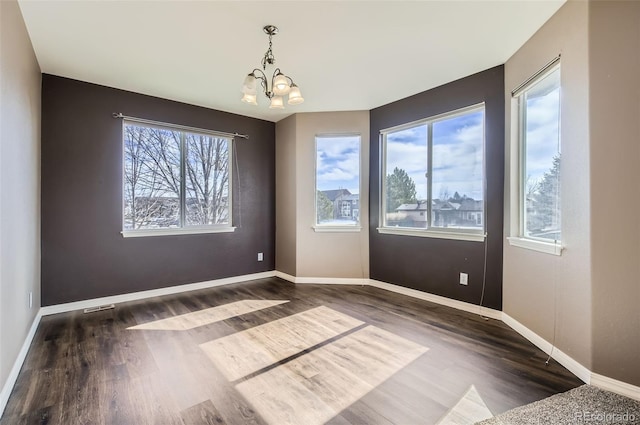 unfurnished dining area with visible vents, baseboards, dark wood-type flooring, and a notable chandelier