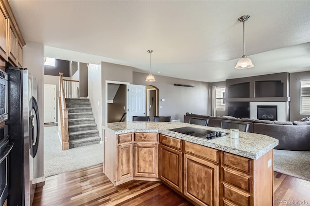 kitchen featuring dark wood-style floors, black electric cooktop, light countertops, and stainless steel fridge with ice dispenser