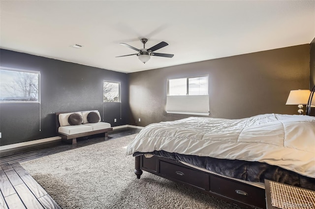 bedroom with visible vents, baseboards, ceiling fan, and wood finished floors