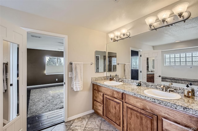 full bath with double vanity, a sink, visible vents, and baseboards