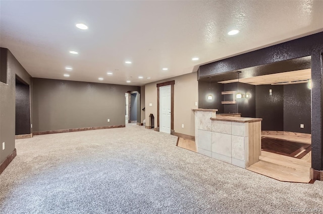 interior space with recessed lighting, arched walkways, baseboards, and light colored carpet