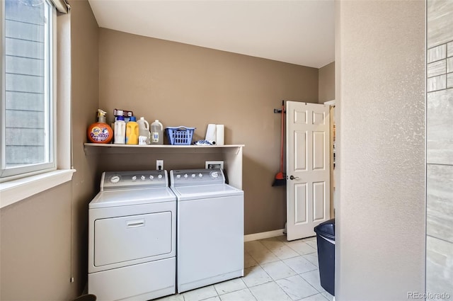 laundry area with baseboards, laundry area, light tile patterned floors, and washer and dryer