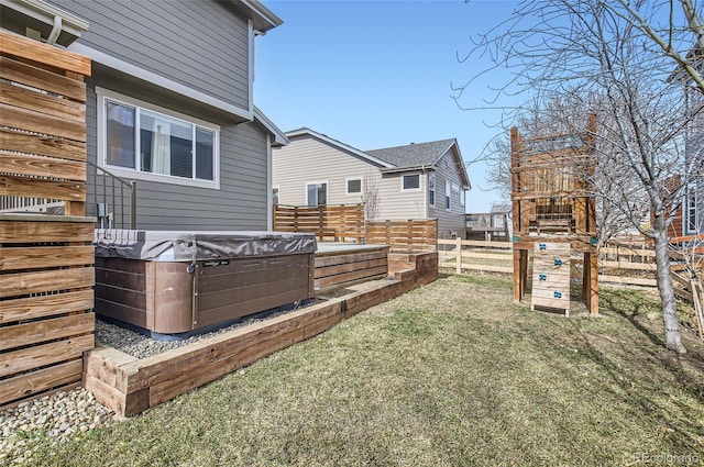 view of yard featuring fence and a hot tub